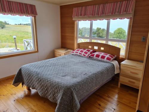 a bedroom with a bed with two pillows on it at Cabaña 3D 1B, Curaco de Velez in Curaco de Velez