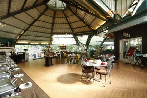 una habitación con mesas y sillas en un edificio en The Solluna Resort, en Garjia