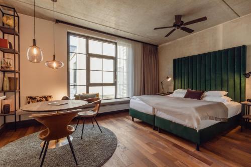 a bedroom with a large bed and a table and chairs at Gastwerk Hotel Hamburg in Hamburg