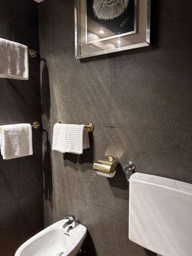 LU Suites في تورينو: حمام مع حوض ومرحاض ومرآة