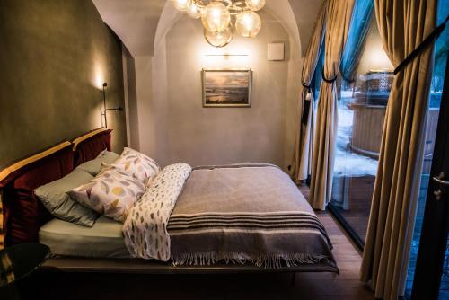 a bedroom with a bed and a window and a chandelier at Silma Retreat in Haapsalu