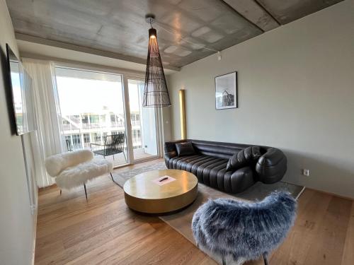 a living room with a leather couch and a table at STAY Nordhavn in Copenhagen