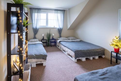 a attic bedroom with two beds and a window at Baltamiškio slėnis in Baltamiškis