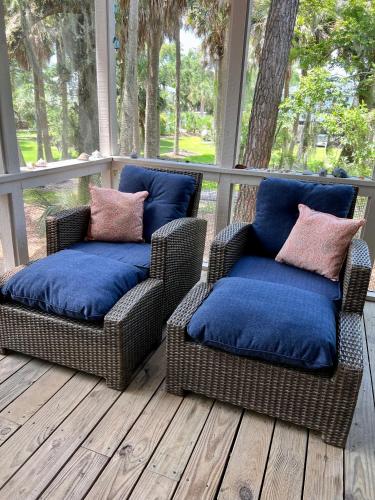 two wicker chairs with blue cushions on a porch at Change in Attitude - 2BR Condo Golfin’, Fishin’, Beachin’ Everyday in Edisto Island