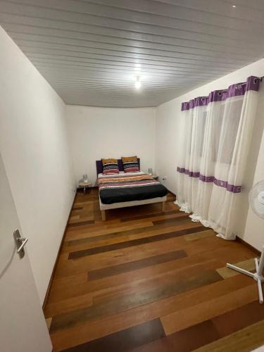 una camera con letto e pavimento in legno di Appartement zen Rémire a Rémire-Camp