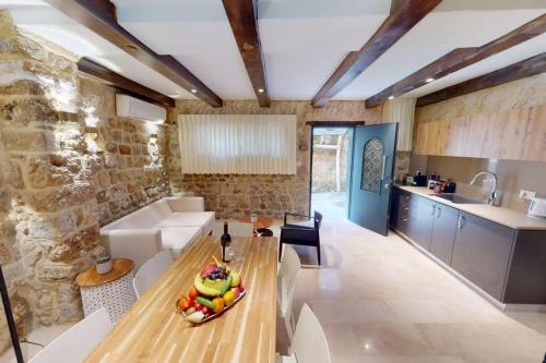 a kitchen and living room with a wooden table in a room at The house in the Ramchal in Acre