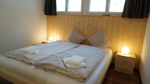 a bedroom with a bed with two pillows on it at Ufem Egg Ferienwohnungen in Innertkirchen