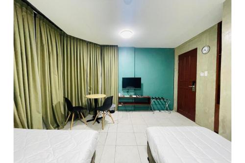 a room with two beds and a table with chairs at OYO 925 Rcee Place in Cebu City