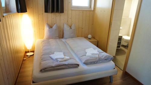 a bed with white sheets and pillows on it at Ufem Egg Ferienwohnungen in Innertkirchen