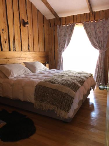 a bedroom with a bed and a window with curtains at Terrazas altos de Gamboa in Castro