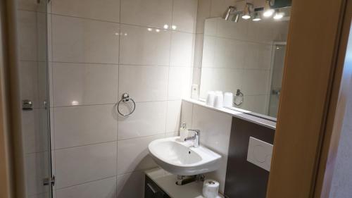 a white bathroom with a sink and a shower at Ufem Egg Ferienwohnungen in Innertkirchen