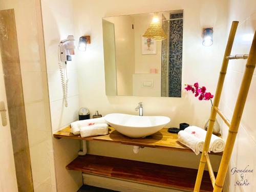 a bathroom with a sink and a mirror at Accès Direct Plage, Magnifique Vue Mer, Les Gwada Studios, Village Vacances in Sainte-Anne