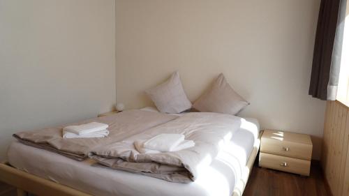 a white bed with two pillows on top of it at Ufem Egg Ferienwohnungen in Innertkirchen