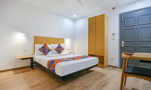 um quarto com uma cama e uma porta azul em FabHotel Indraprastha - Shahdara em Nova Deli