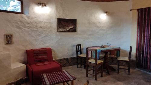 sala de estar con mesa, sillas y sofá en Casa Pachamama en Tilcara