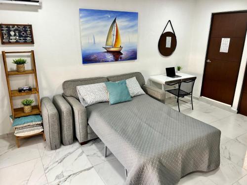 a bedroom with a bed and a sailboat painting on the wall at 5E Roof- Penthouse Manzanillo exclusivo con alberca in Manzanillo