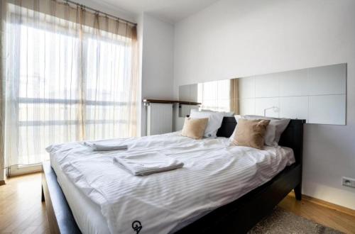 a bedroom with a large bed with white sheets and pillows at Golden Apartments Warsaw - Big and Bright Apartment in Platinum Towers- Browary- Grzyb61A in Warsaw