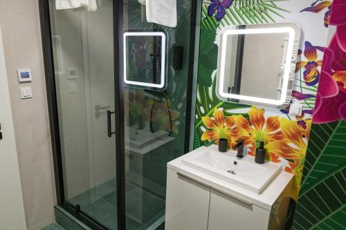 een badkamer met een wastafel en een douche met een spiegel bij Apartmány Vanilla Karviná in Karviná