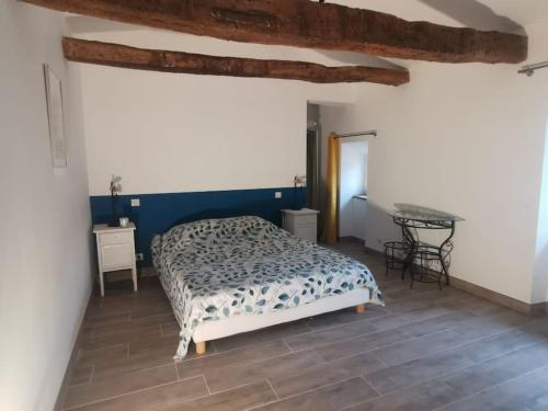 une chambre avec un lit et une table dedans dans l'établissement Bâtisse Provençale avec piscine, à Banon