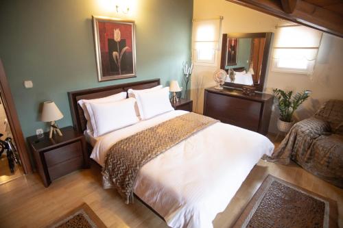 a bedroom with a bed and a chair and a mirror at Soffitta House Sofi! in Florina