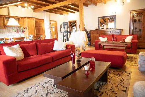 a living room with red couches and a coffee table at Soffitta House Sofi! in Florina