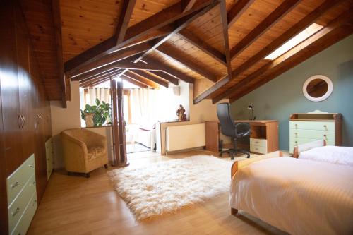 um quarto com uma cama, uma secretária e uma cadeira em Soffitta House Sofi! em Florina