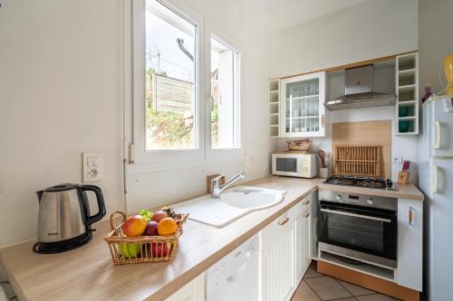 a kitchen with a counter with a sink and a refrigerator at Pont L'Abbé, maison avec jardin pour 4 in Pont-lʼAbbé