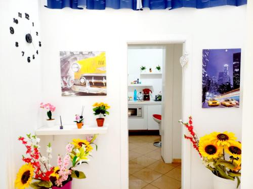 twee afbeeldingen van een keuken met zonnebloemen op de muur bij B&B Family - Affitta camere in Reggio di Calabria
