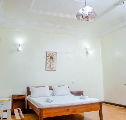 Bett in einem weißen Zimmer mit einer Decke in der Unterkunft LOTUS HOTEL in Diego Suarez