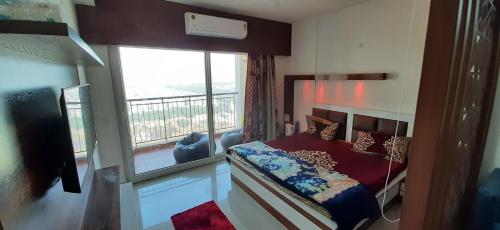 ein Schlafzimmer mit einem Bett und einem großen Fenster in der Unterkunft Short Stays in Fully Furnished Service Apartment in Noida