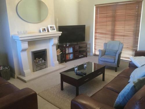 a living room with a couch and a fireplace at Home On The Edge Of Ireland! in Belmullet