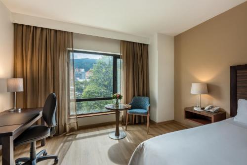 a hotel room with a bed and a desk and a window at Hotel Morrison 84 in Bogotá