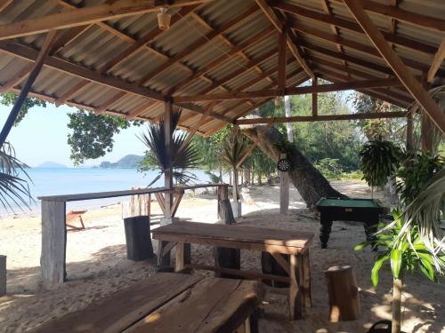 a wooden pavilion on the beach with a pool table at Miss You Beach Resort Koh Mak in Ko Mak