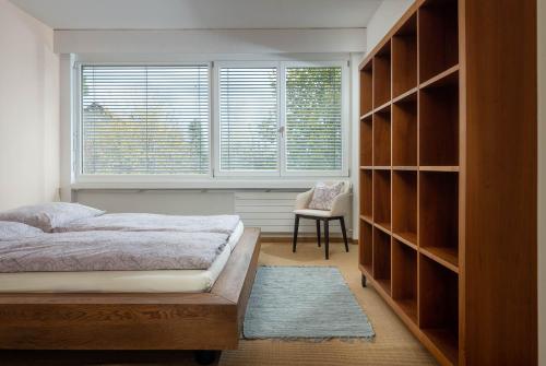 a bedroom with a bed and a window and a chair at Luxury apartment with terrace and garden free parking smart TV etc in St. Gallen