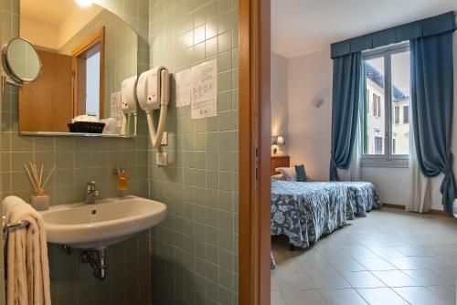 a bathroom with a sink and a bed in a room at Hotel Bonifacio in Florence