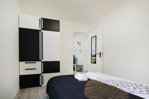 1 dormitorio con 1 cama con muebles blancos y negros en SweetMoulinHome 5 km from Paris en Le Plessis-Robinson