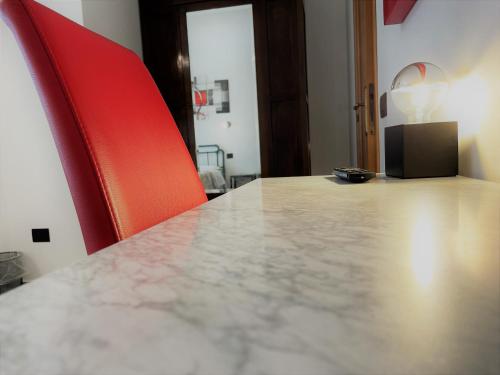 a table with two red chairs and a counter top at B&B Villa Incrocca in Cerreto dʼEsi