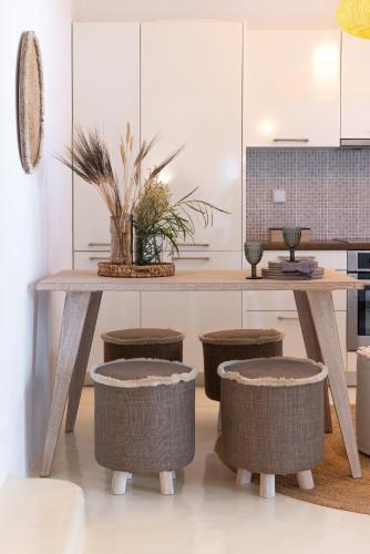 a kitchen with a wooden table and stools at Amalgam Homes Paros in Ambelas