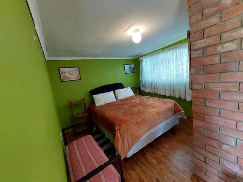 a bedroom with a bed and a brick wall at Lion Rock View Guesthouse in Maseru