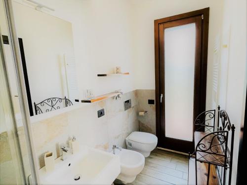 a white bathroom with a toilet and a sink at B&B Villa Incrocca in Cerreto dʼEsi