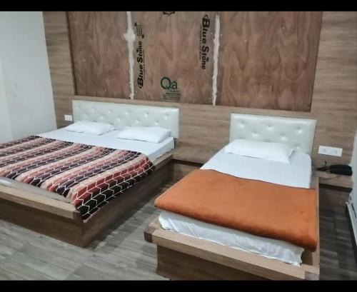 two beds sitting next to each other in a room at Anant Royal in Govardhan