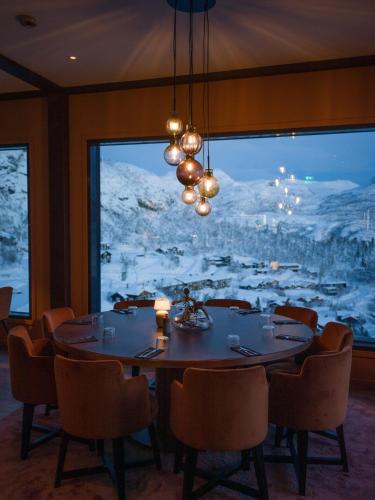 a dining room with a table and chairs and a large window at Skarsnuten Mountain Resort & SPA in Hemsedal