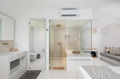a bathroom with a shower and a bed in a room at Cycladic Suites in Fira