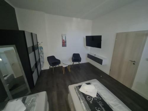 a room with two chairs and a table and a mirror at Apartament Suite 2 in Bernburg