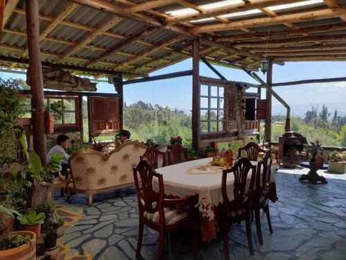 a dining room with a table and chairs with a view at Hotel Rural Granja Agroecoturistica Santa Barbara in Simijaca