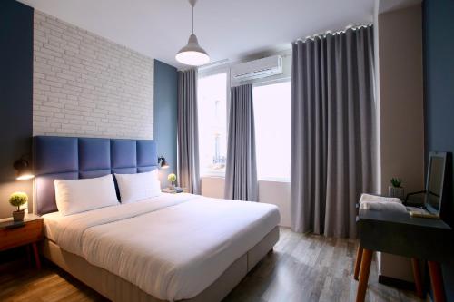 une chambre avec un grand lit et une tête de lit bleue dans l'établissement GK Ermou Str, à Athènes
