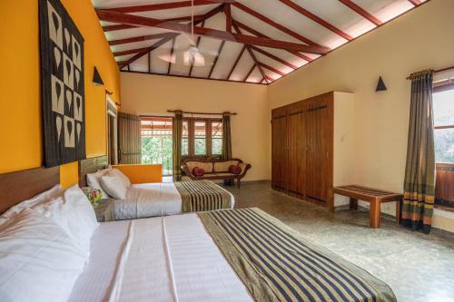 a bedroom with two beds and a couch at Kuru Ganga Villa in Eratnagoda