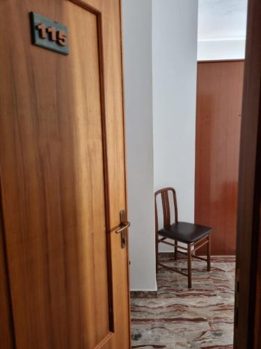 an open door with a chair in a room at Hotel Plammas in Santa Maria Navarrese