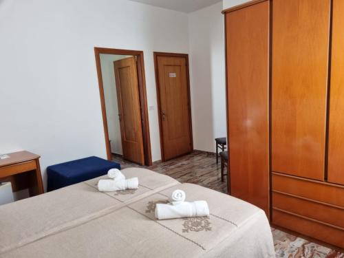 a bedroom with a bed with two towels on it at Hotel Plammas in Santa Maria Navarrese