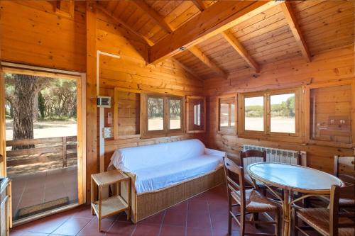 ein Schlafzimmer in einem Blockhaus mit einem Bett und einem Tisch in der Unterkunft Residence La Canova II in Marina di Grosseto